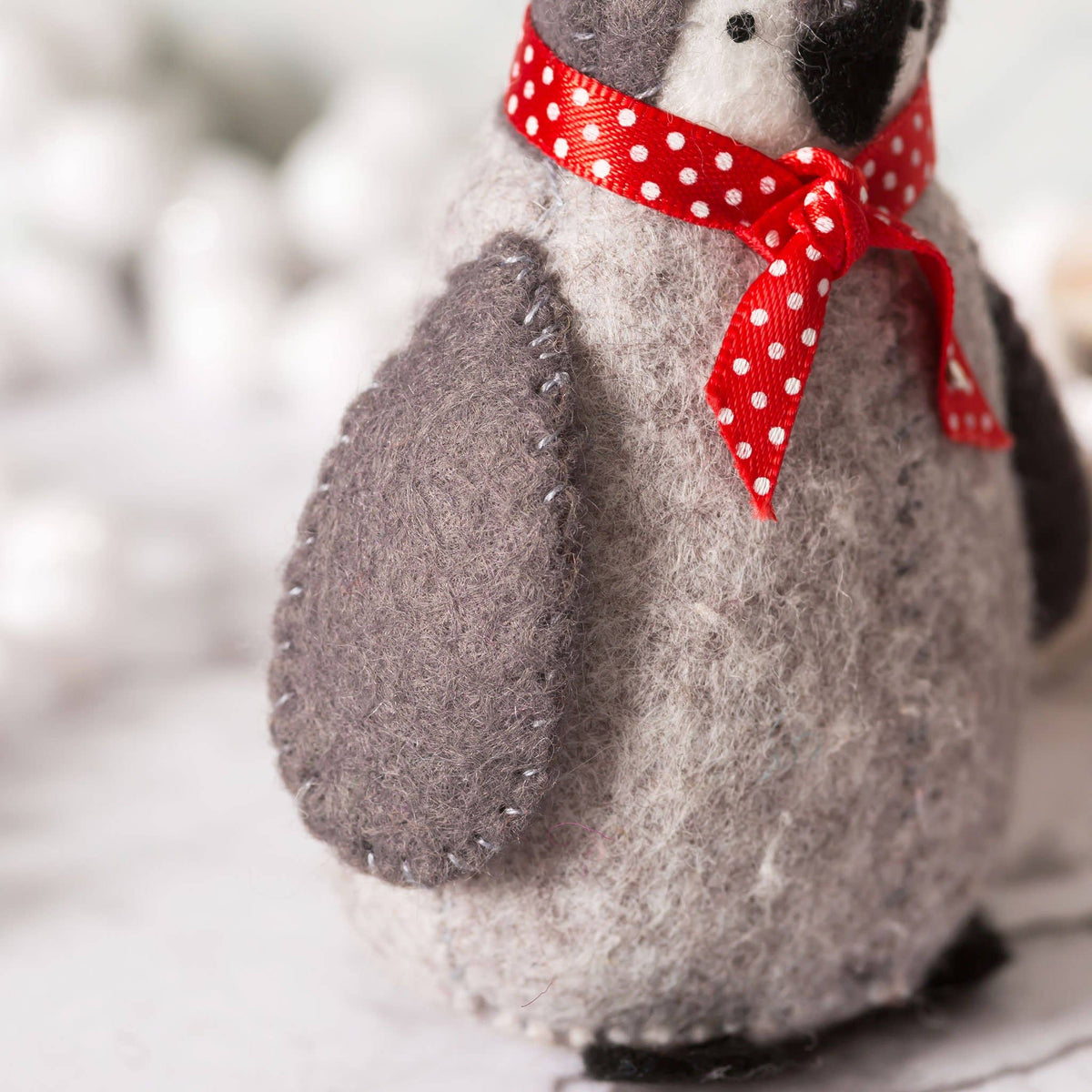 Stuffed animal with a red polka dot bow on a penguin close up
