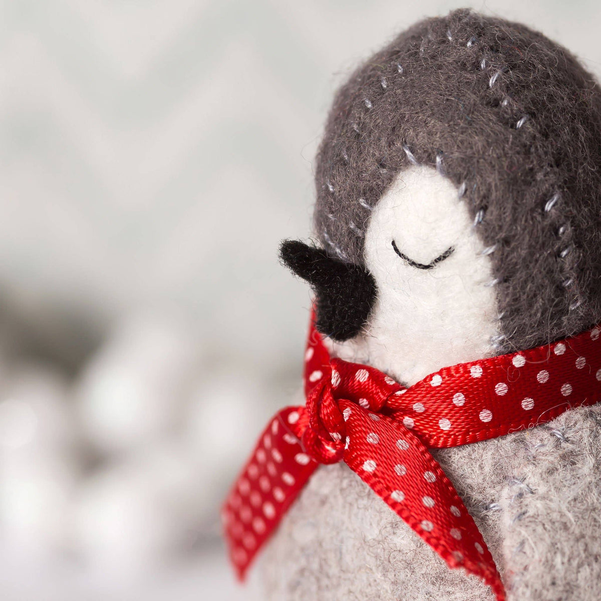 Stuffed animal with a red polka dot bow on a penguin
