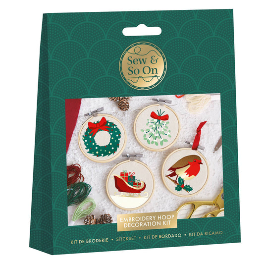 Embroidery hoop decoration kit packaging with Christmas-themed designs on a green background.